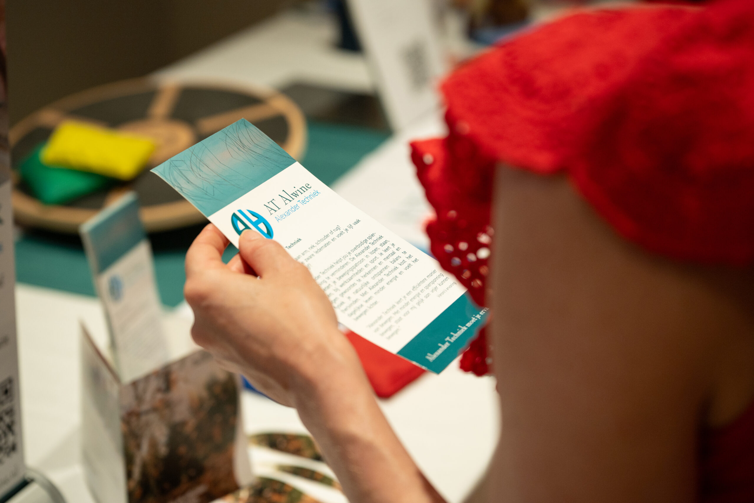 Bezoeker leest de folder van AT Alwine over Alexander Techniek