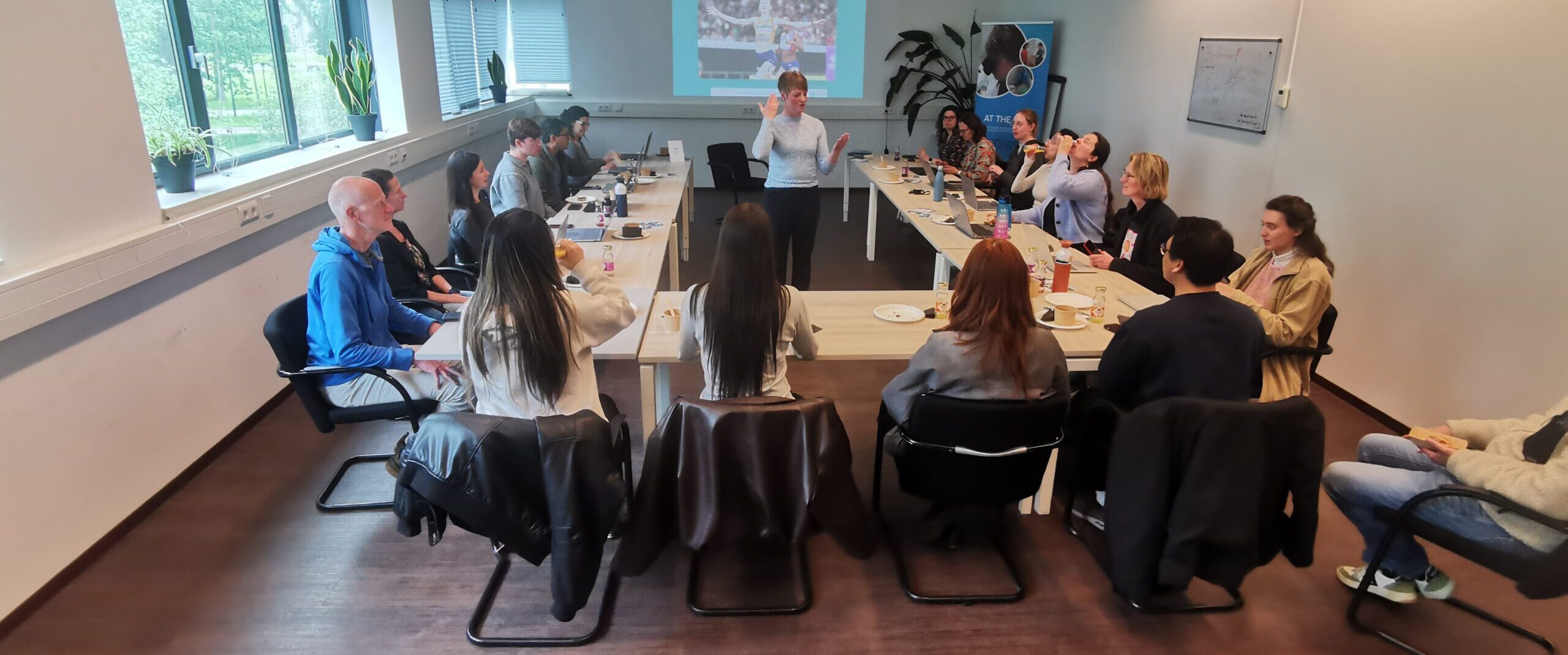 Alwine geeft de workshop Sit Smart, Work Pain-Free aan een groep medewerkers bij BioPartner in Leiden
