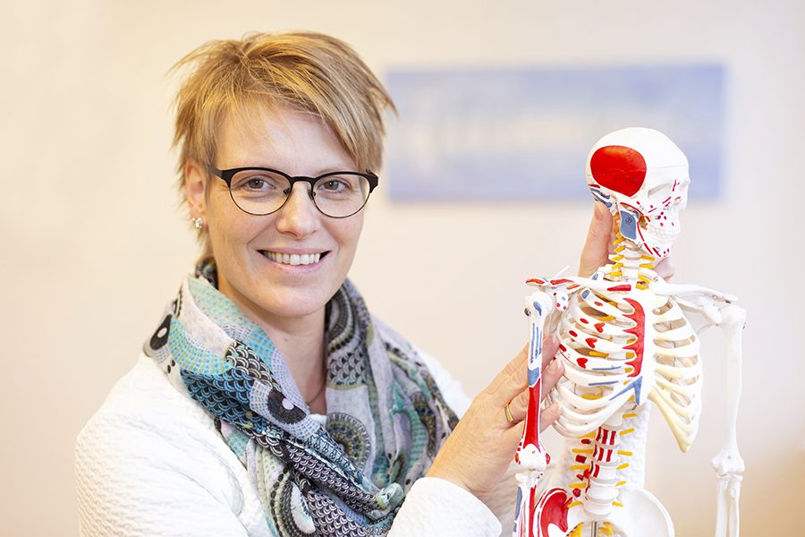 Alwine Kruisselbrink legt met een anatomisch model uit hoe houding en spierspanning werken